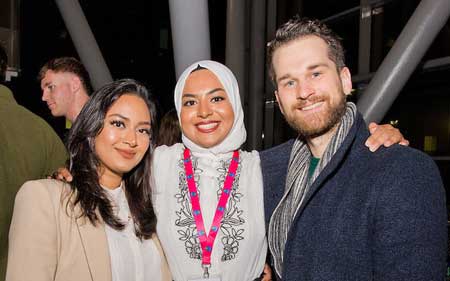 Three smiling students attending an EGA event