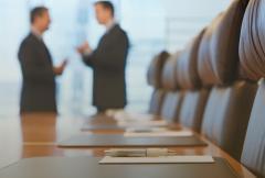 Blurred view of two people talking in a boardroom