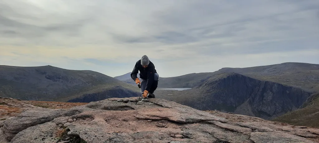 A person taking a rock sample in the cairngorm mountains