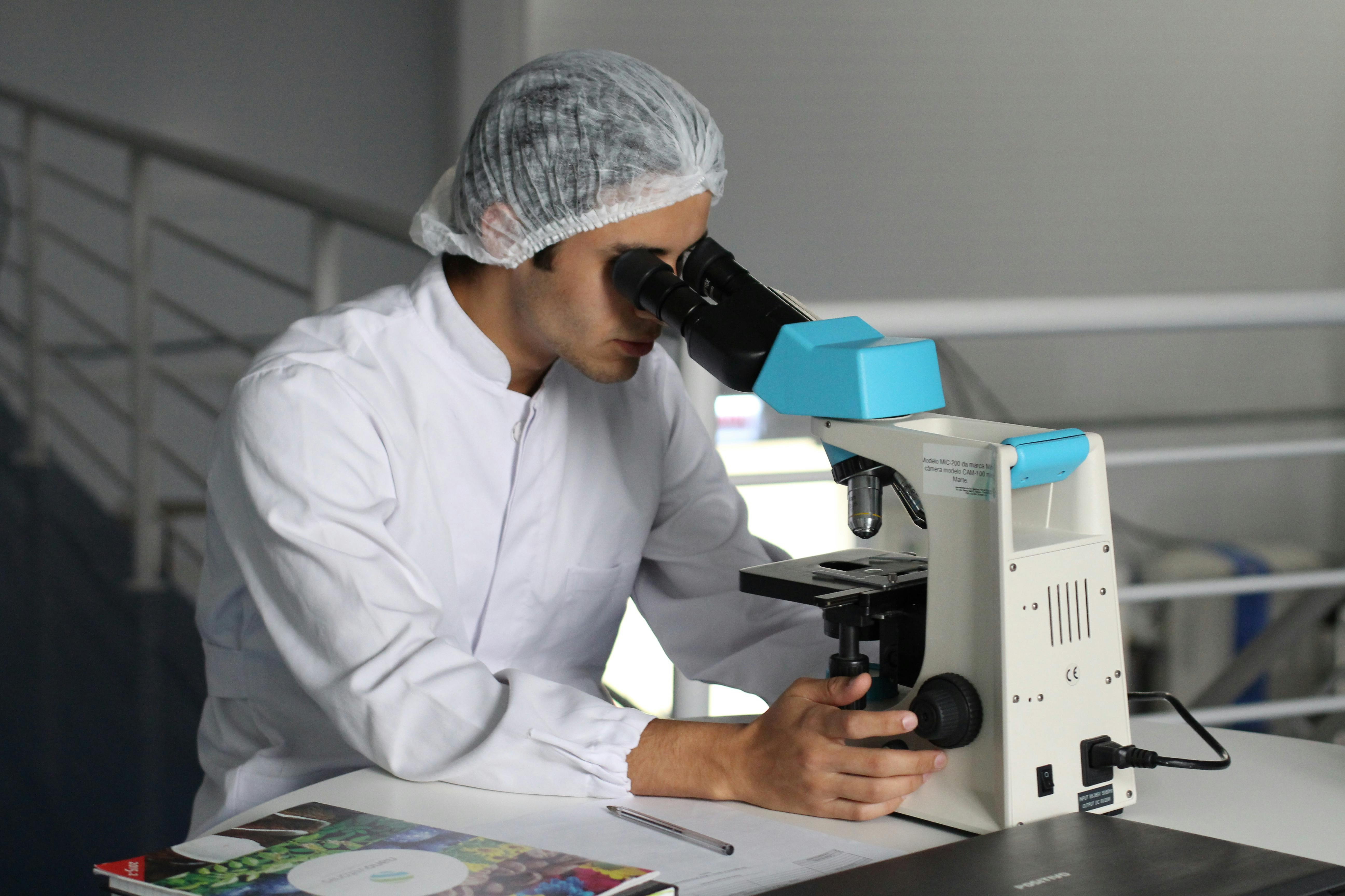 man using a microscope