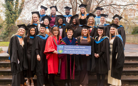 Group of graduates in caps and gowns with academics