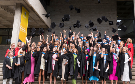 Group of graduates throwing caps in the air