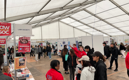 Students looking at UCD Societies stands in a marquee