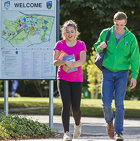 A man and a woman take a walk around UCD Campus